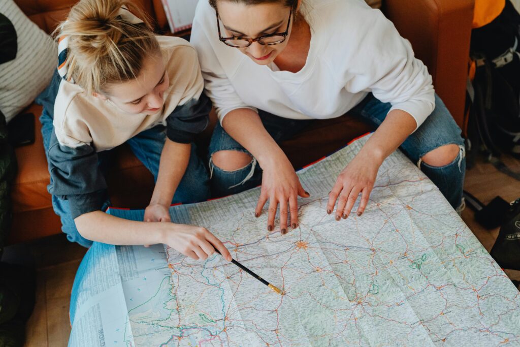 A mother and daughter plan their journey using a map, symbolizing adventure and bonding.