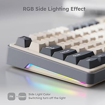 Close-up of a compact mechanical keyboard with RGB side lighting effect, showing multicolor light strip along the edge and grey keycaps on a minimalist background.