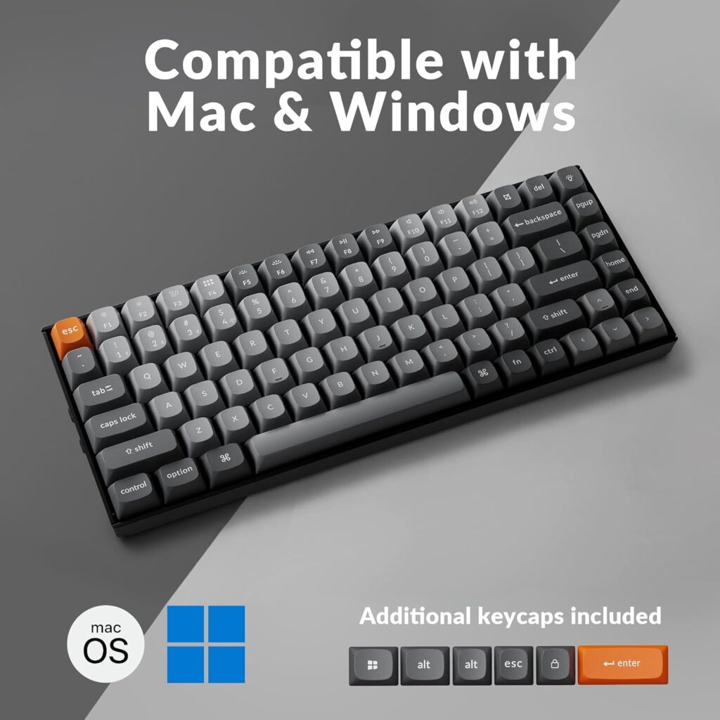 Compact grey mechanical keyboard with black frame and orange Escape key, shown on a grey background with text “Compatible with Mac & Windows” above it.